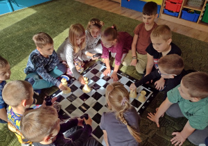 Dzieci oglądają figury do gry w szachy